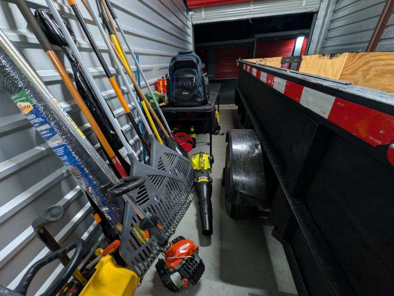 Trimmers, blower, trailer, and landscaping tools ready for service