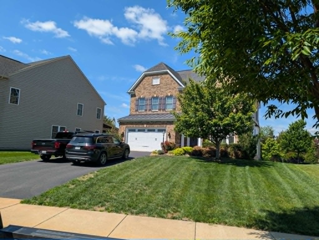 Brick home front lawn with diagonal professional mowing stripes