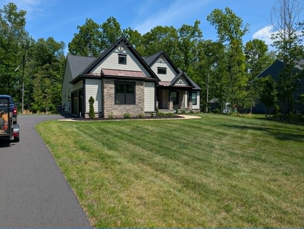 Large residential lawn with professional mowing stripes and foundation mulch beds