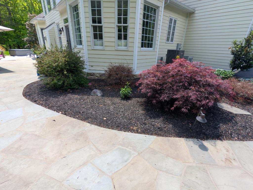 Fresh mulch along a grey deck with clean edging